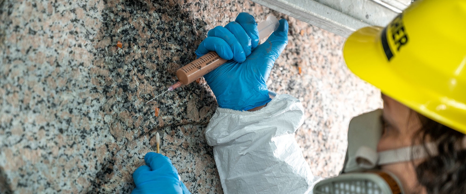 Schadhafte Stellen am Obelisken werden von Restauratoren gefestigt