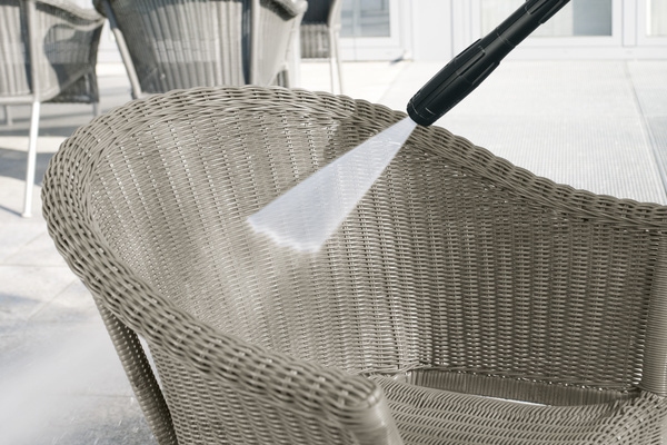 Nettoyer le mobilier de jardin en rotin Une chaise en rotin est nettoyée avec de la mousse