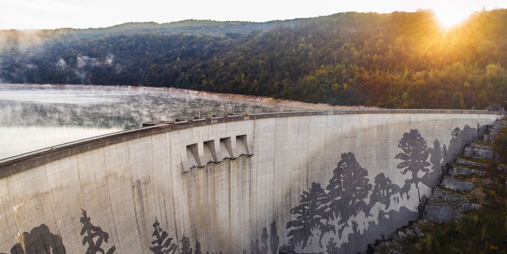 Das Reverse Graffiti am Staudamm von Vouglans im Morgenlicht Das Reverse Graffiti am Staudamm von Vouglans im Morgenlicht