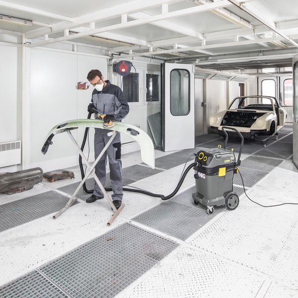 Personne utilisant un aspirateur de sécurité Kärcher dans un atelier de peinture