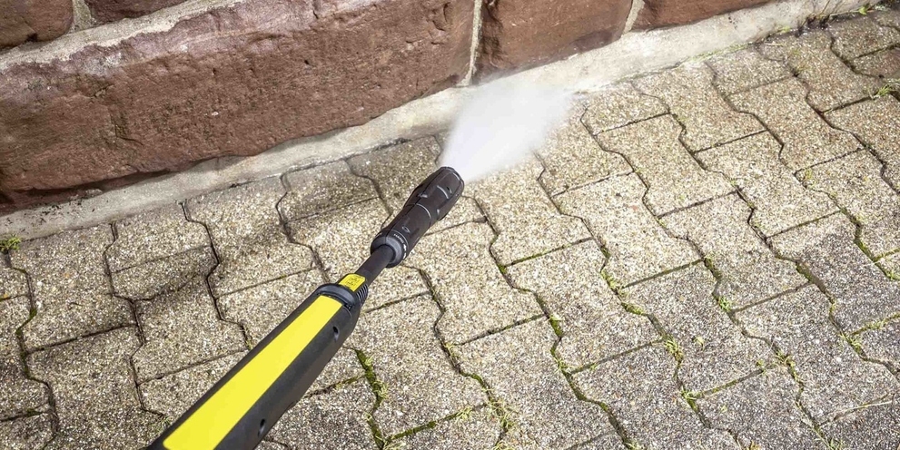 Nettoyer les bordures de pavés à haute pression Une bordure de pavé est nettoyée avec un nettoyeur haute pression Kärcher