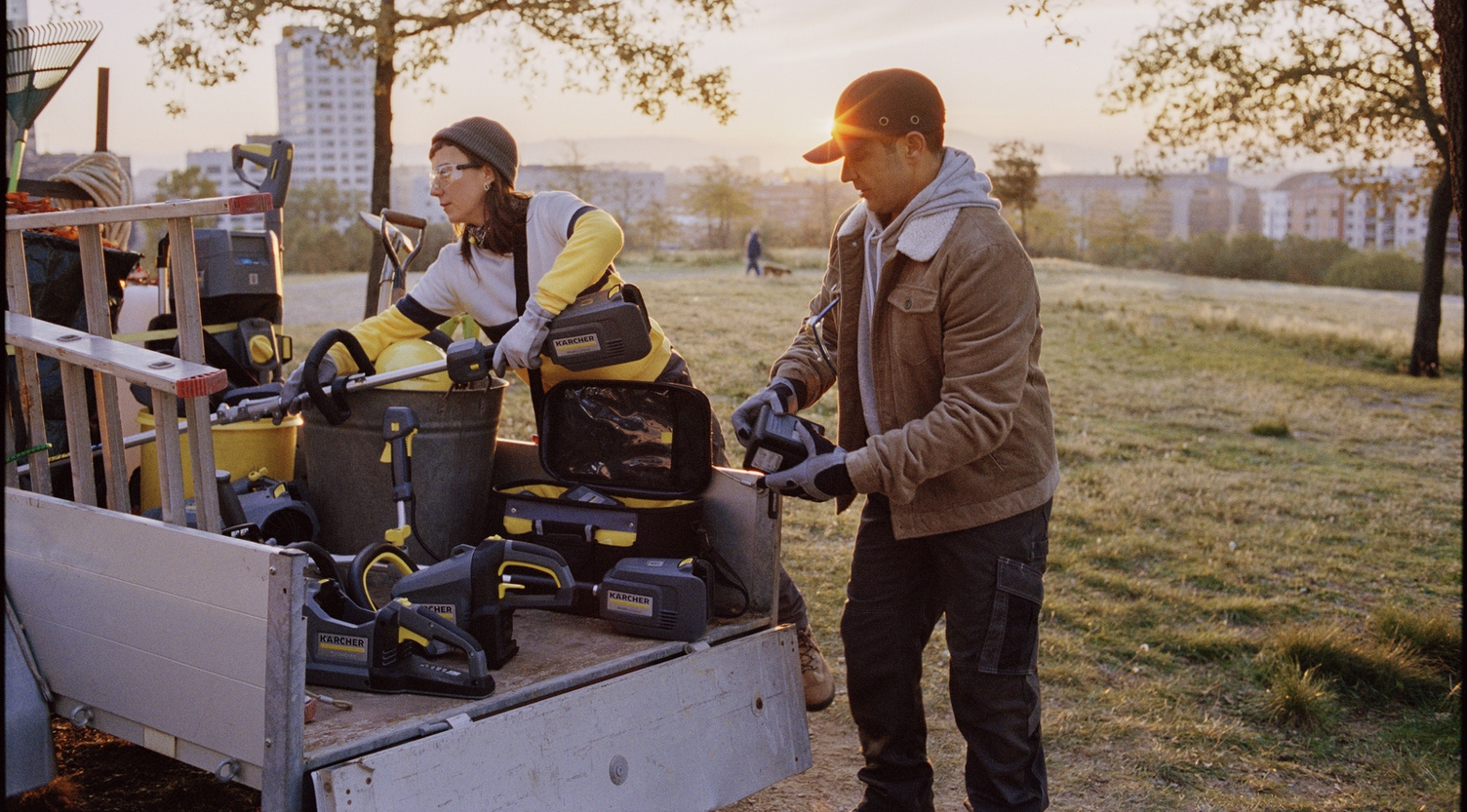 Kärcher Outdoor Power Equipment für kommunale Reinigungsaufgaben Zwei Personen beladen einen Anhänger mit Kärcher Outdoor Power Equipment