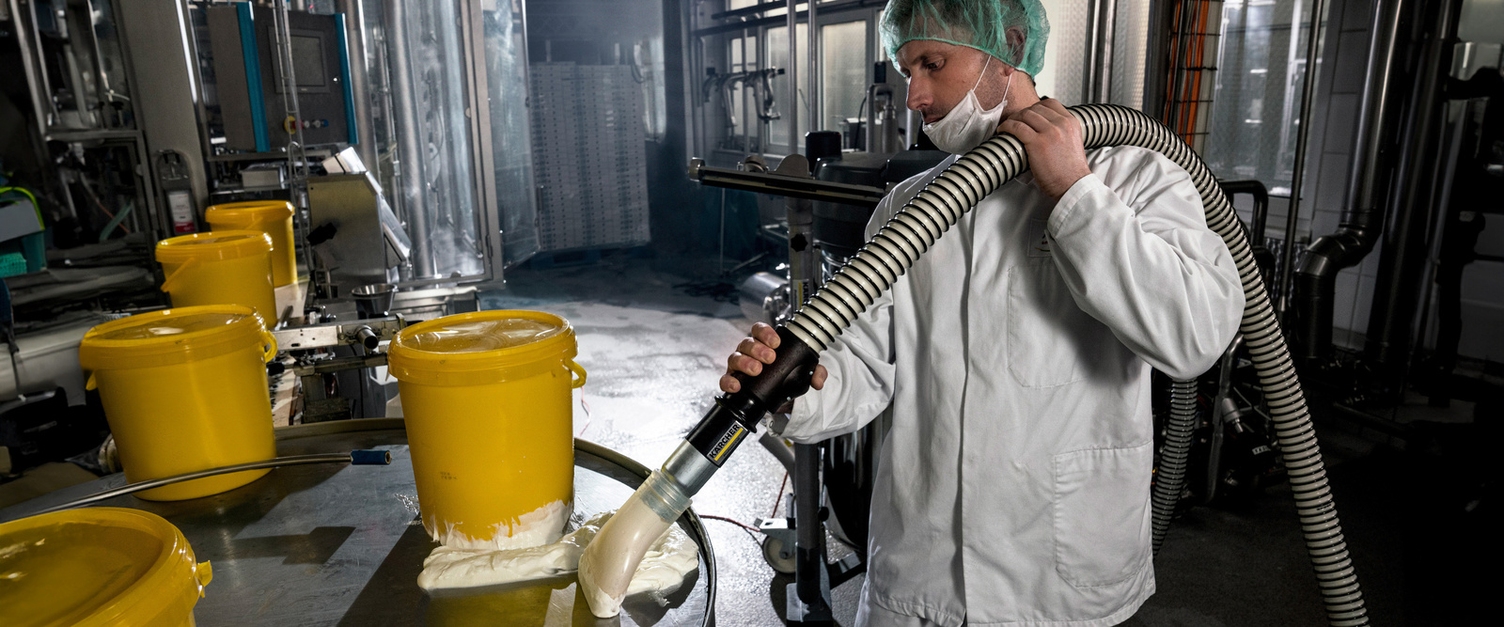 Ein Mann saugt Partikel mit dem Industriesauger ab