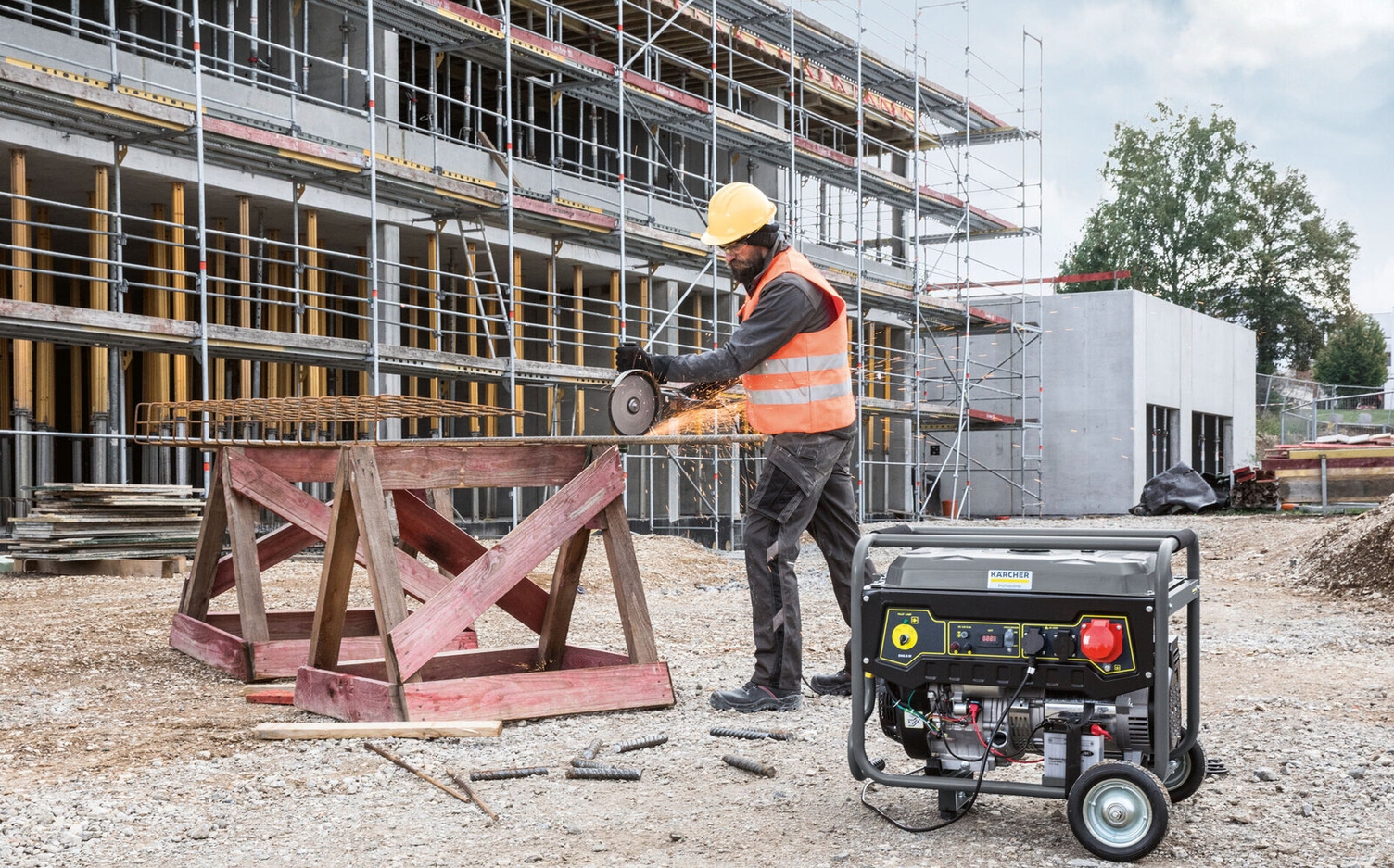 Eine Person arbeitet mit einem Flex-Gerät auf einer Baustelle mit Hilfe eines Kärcher Generators
