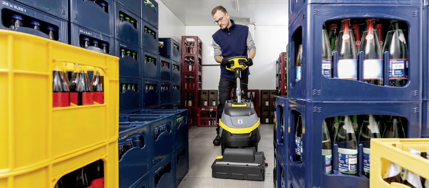 Eine Person reinigt das Kühlhaus mit einer Maschine