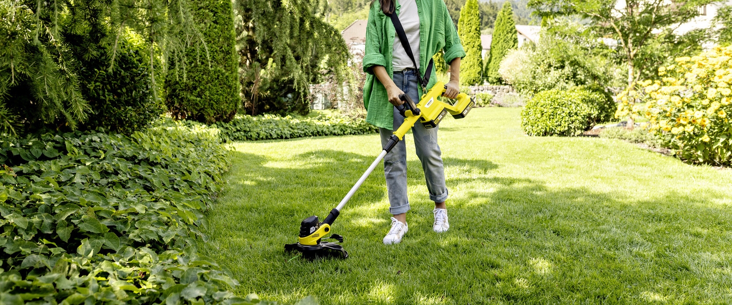 Kärcher Akku-Rasentrimmer Person benutzt den Kärcher Akku-Rasentrimmer im Garten