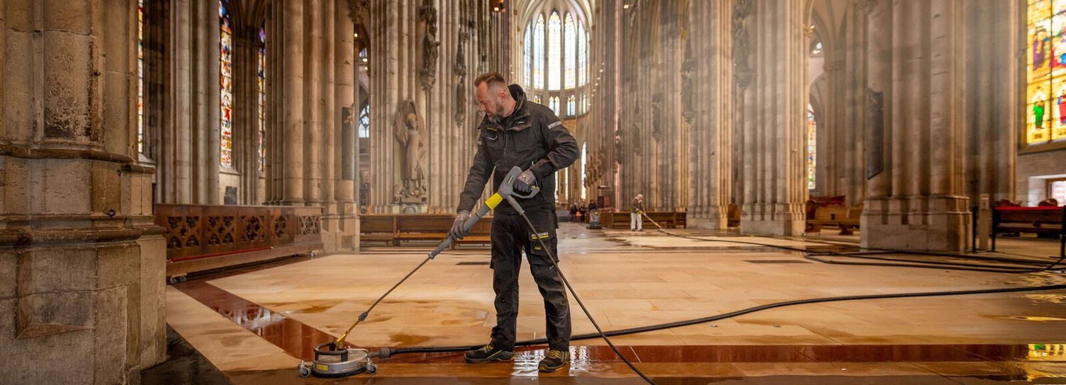 Eine Person reinigt den Innenraum des Kölner Doms