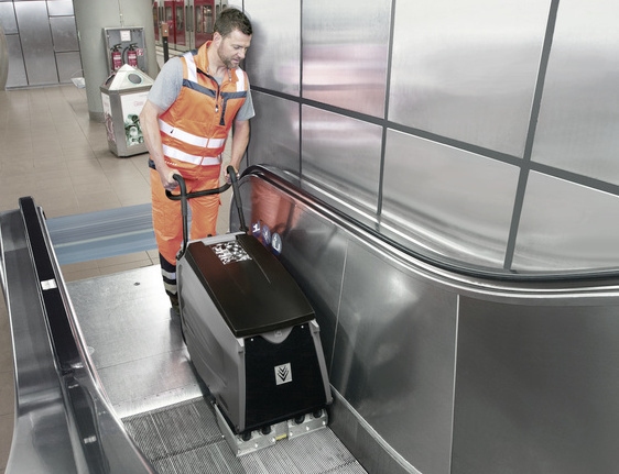 Ein Mann säubert eine Rolltreppe mit einem Rolltreppenreiniger