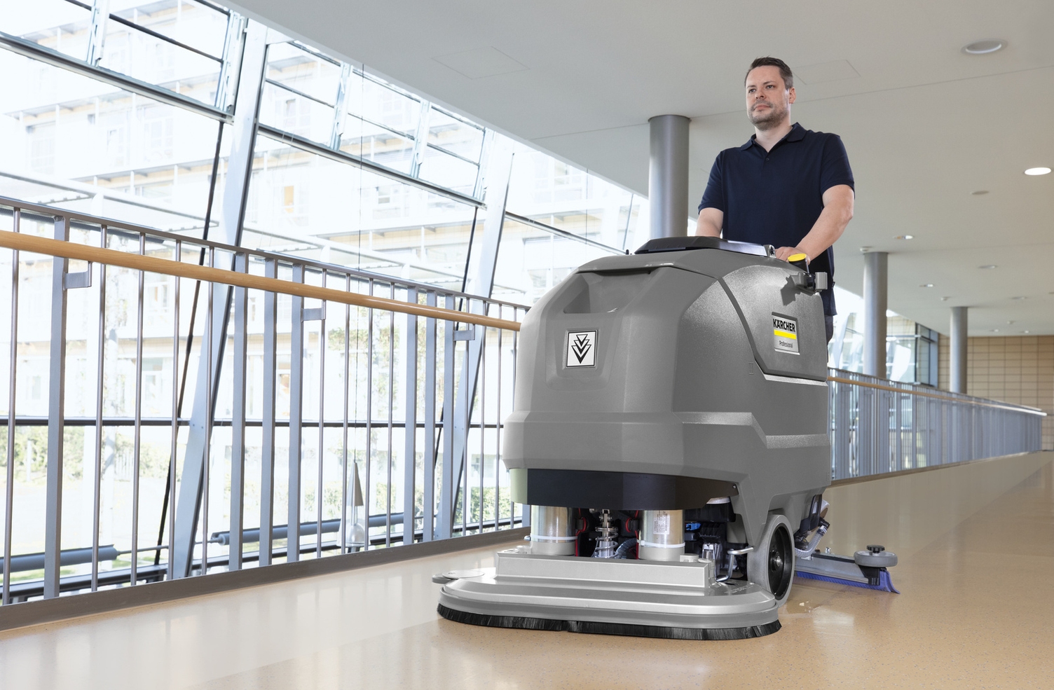 Ein Mann reinigt mit einer Scheuersaugmaschine den Boden eines Seniorenheimes