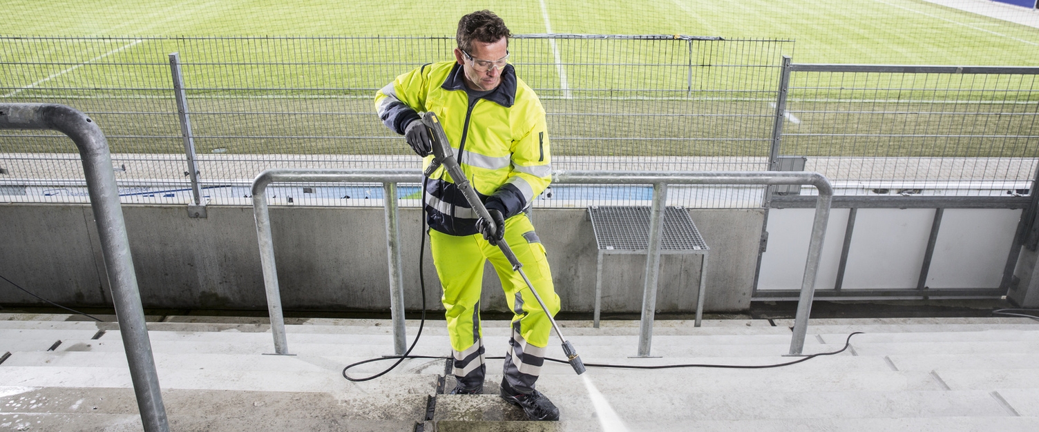 Hochdruckreiniger im Einsatz Ein Mann reinigt mit einem Hochdruckreiniger eine Tribüne