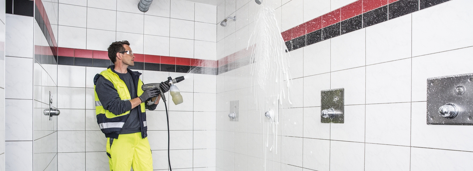 Hochdruckreiniger Ein Mann säubert mit einem Hochdruckreiniger von Kärcher einen Sanitärbereich