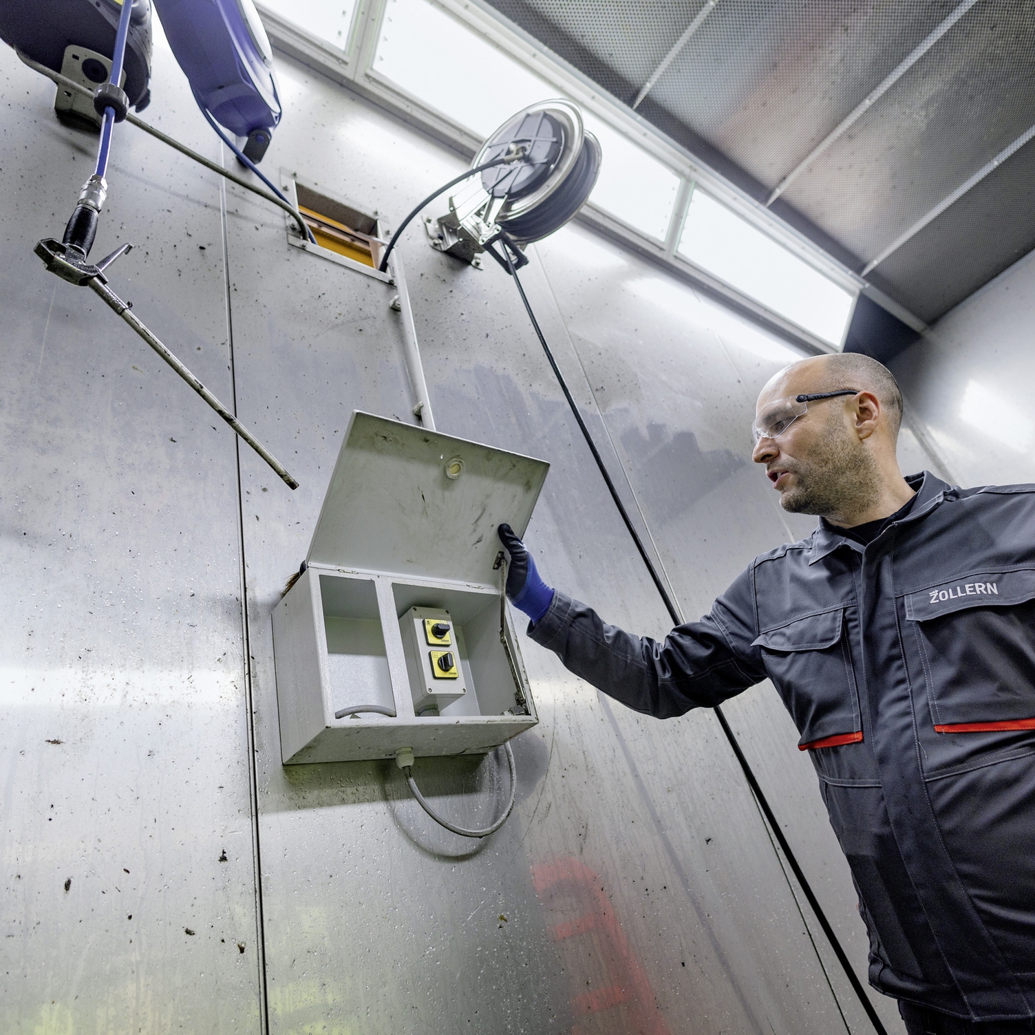 Schaltbox Mann öffnet Schaltbox von stationärem Hochdruckreiniger