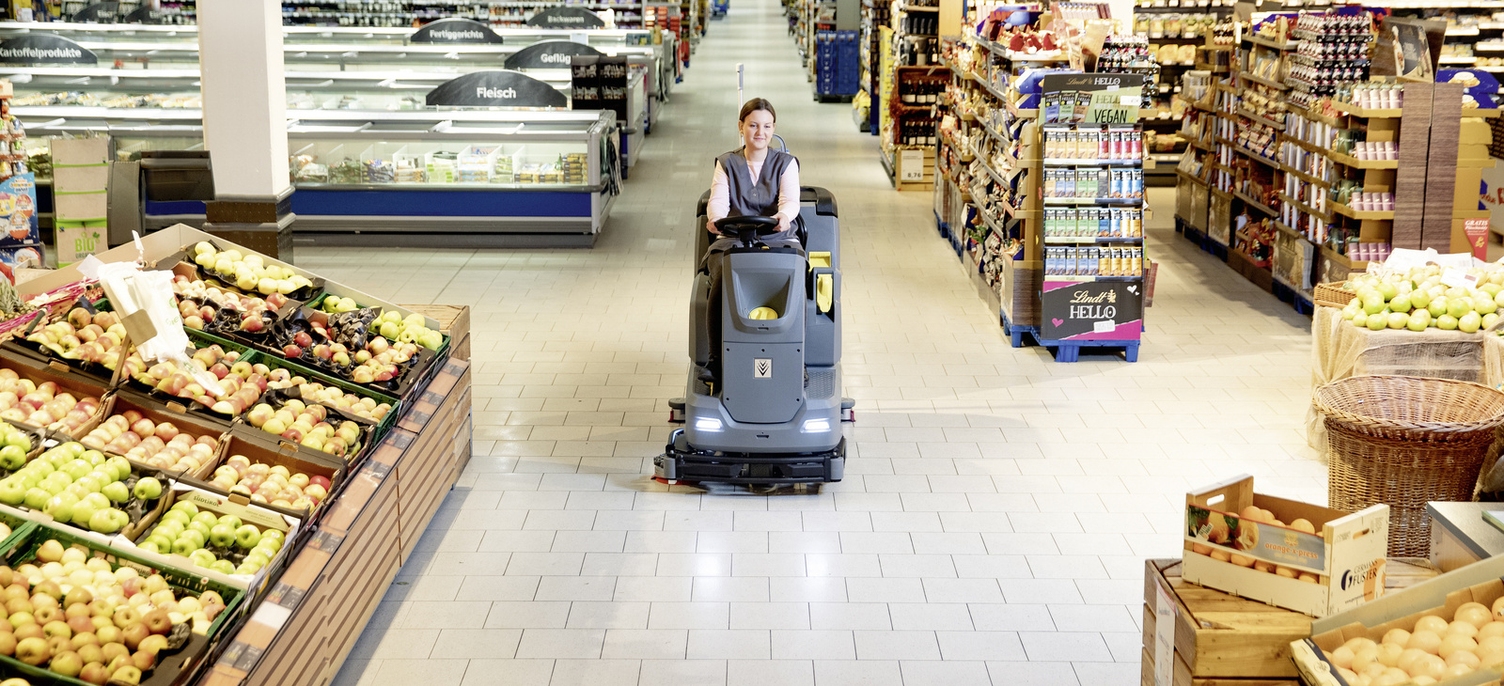 Eine Person reinigt mit einer Scheuersaugmaschine ein Lebensmittelgeschäft