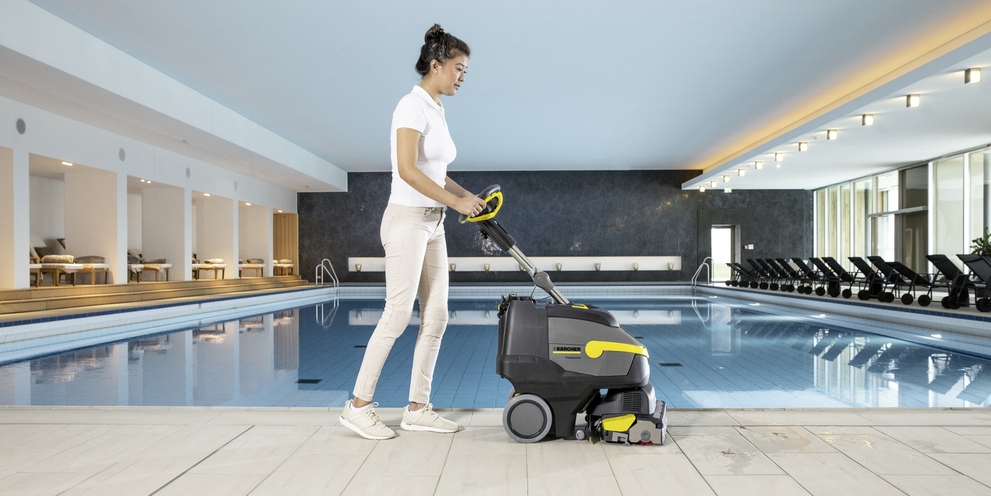 Scheuersaugmaschine im Spa-Bereich Eine Person reinigt den Spa-Bereich mit einer Scheuersaugmaschine
