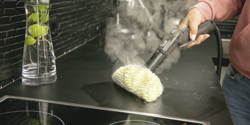 Tuchsets für Dampfreiniger Person reinigt Küchenoberfläche mit Dampfreiniger mit Mikrofasertuch-Aufsatz