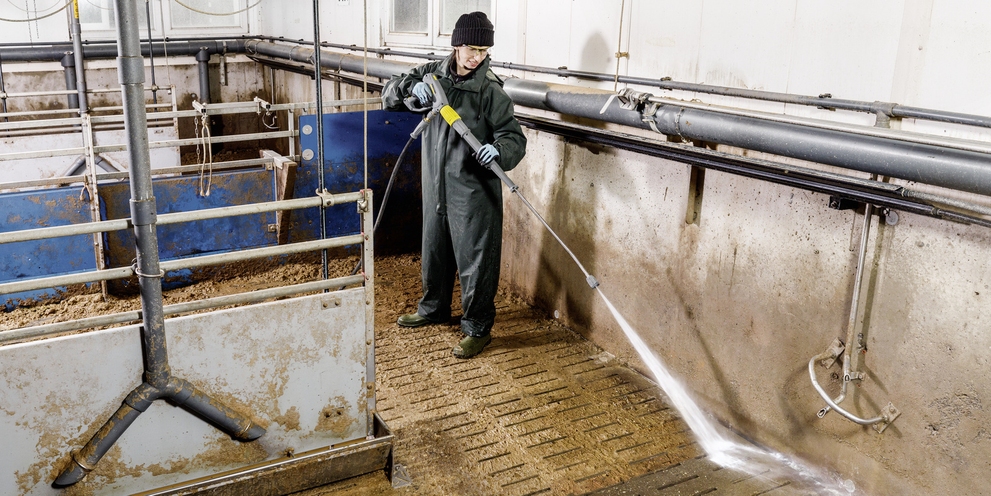 Landwirtschaft Mann reinigt Stall mit Hochdruckreiniger