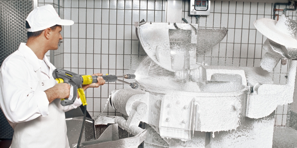 Lebensmittelindustrie Mann reinigt industriellen Mixer mit Hochdruckreiniger