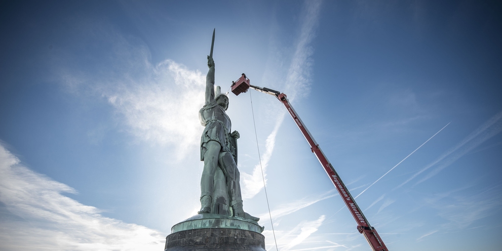 Ein Denkmal wird mithilfe eines Hubsteigers gereinigt
