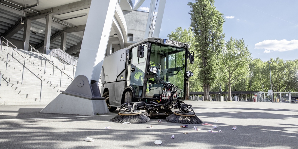 Kehrmaschine im Einsatz Ein Mann reinigt mit einer Kehrmaschine von Kärcher einen Aussenbereich