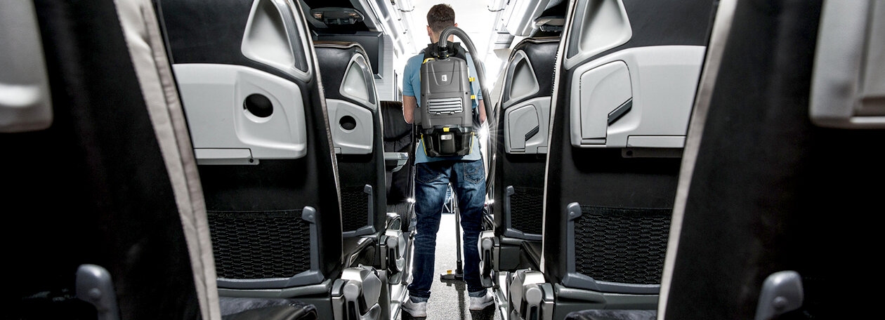 Person cleaning a bus with the battery powered backpack vacuum cleaner
