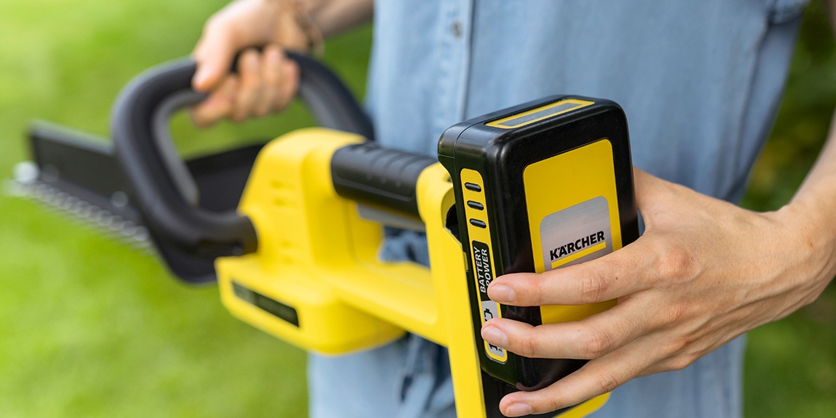 Person setting up the battery for the hedge trimmer