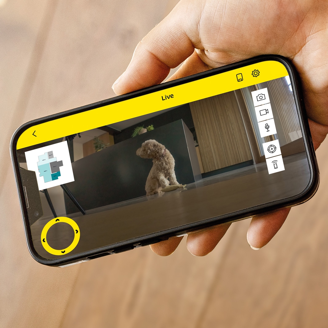 Person controlling robot vacuum by smartphone app