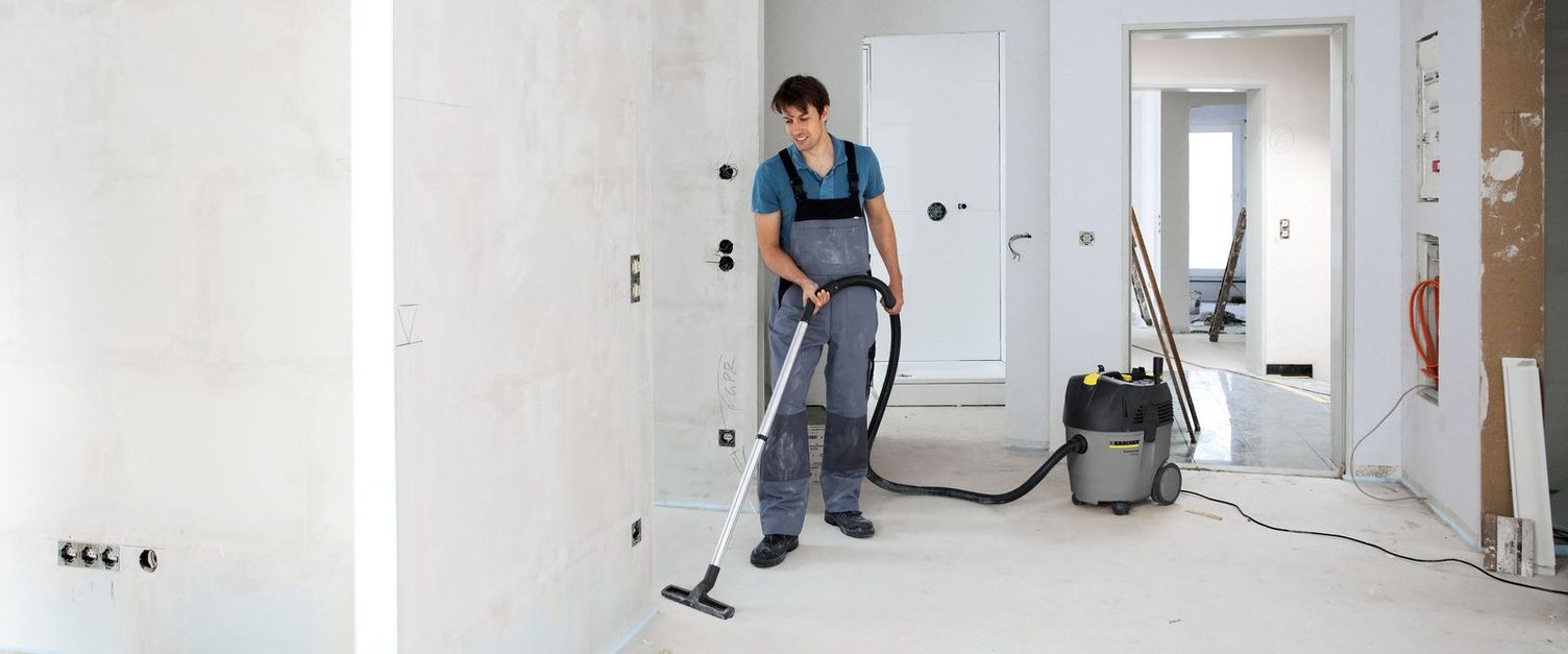 A person cleans the unfinished floor with a Kärcher Wet And Dry Vacuum Cleaner