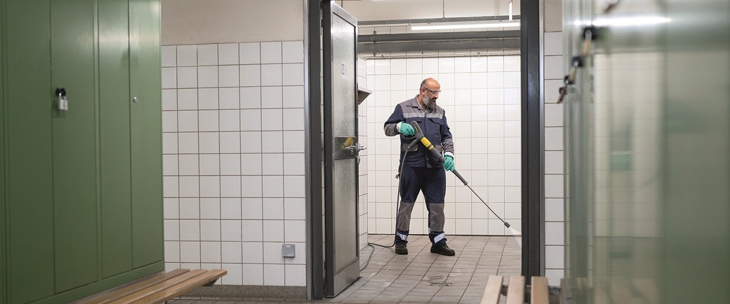 person cleaning showers in Thyssen Krupp production site