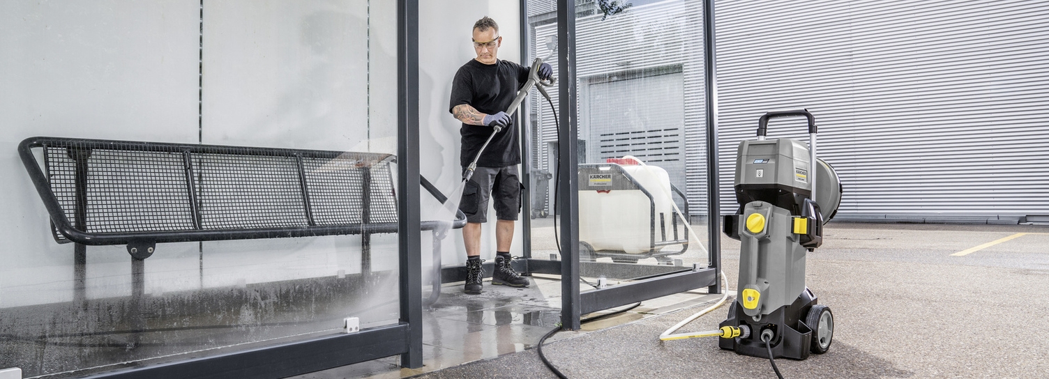 A person is cleaning a smoking area with a Kärcher high-pressure cleaner