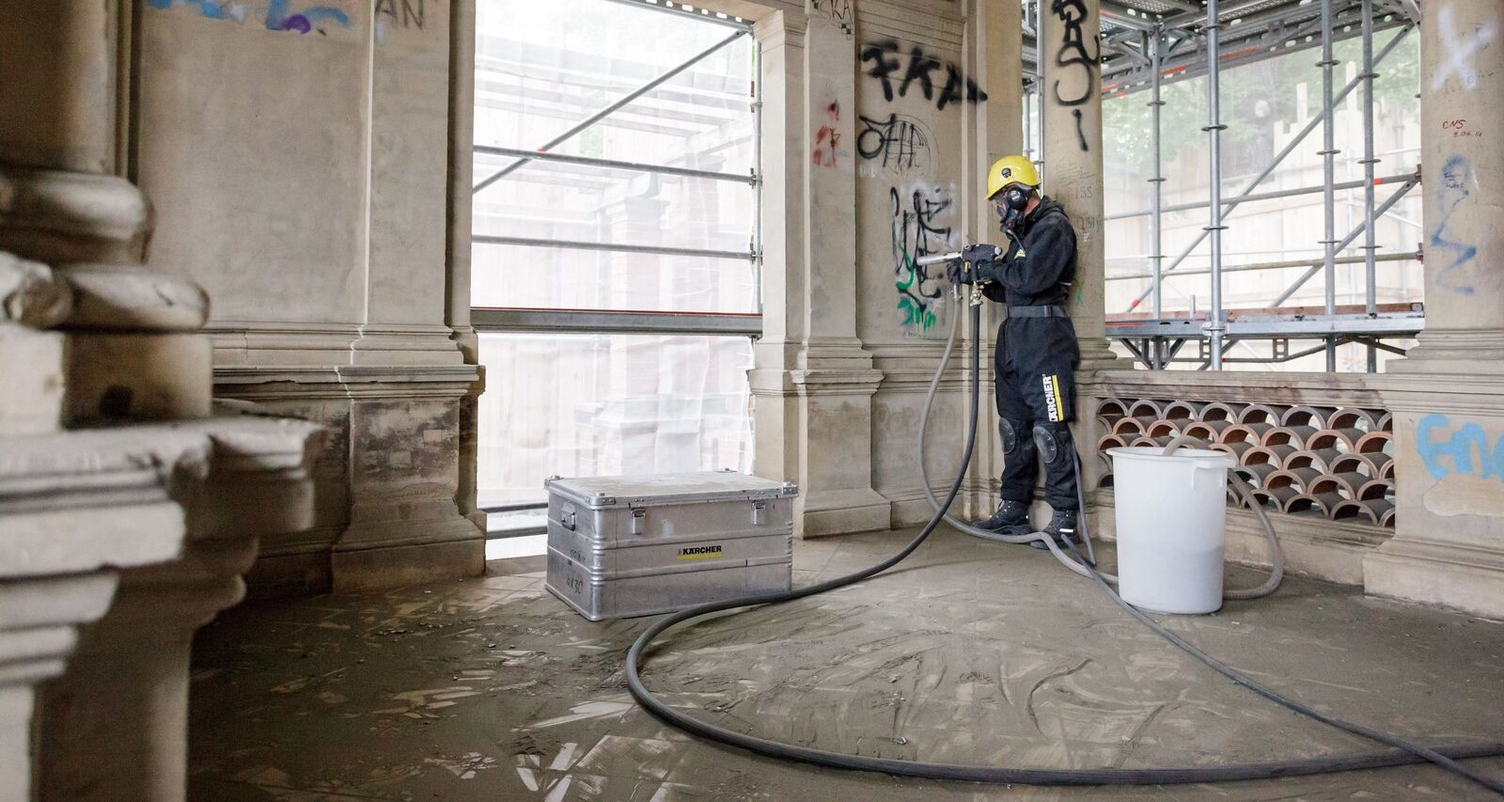 Unwanted graffiti is being removed from a wall