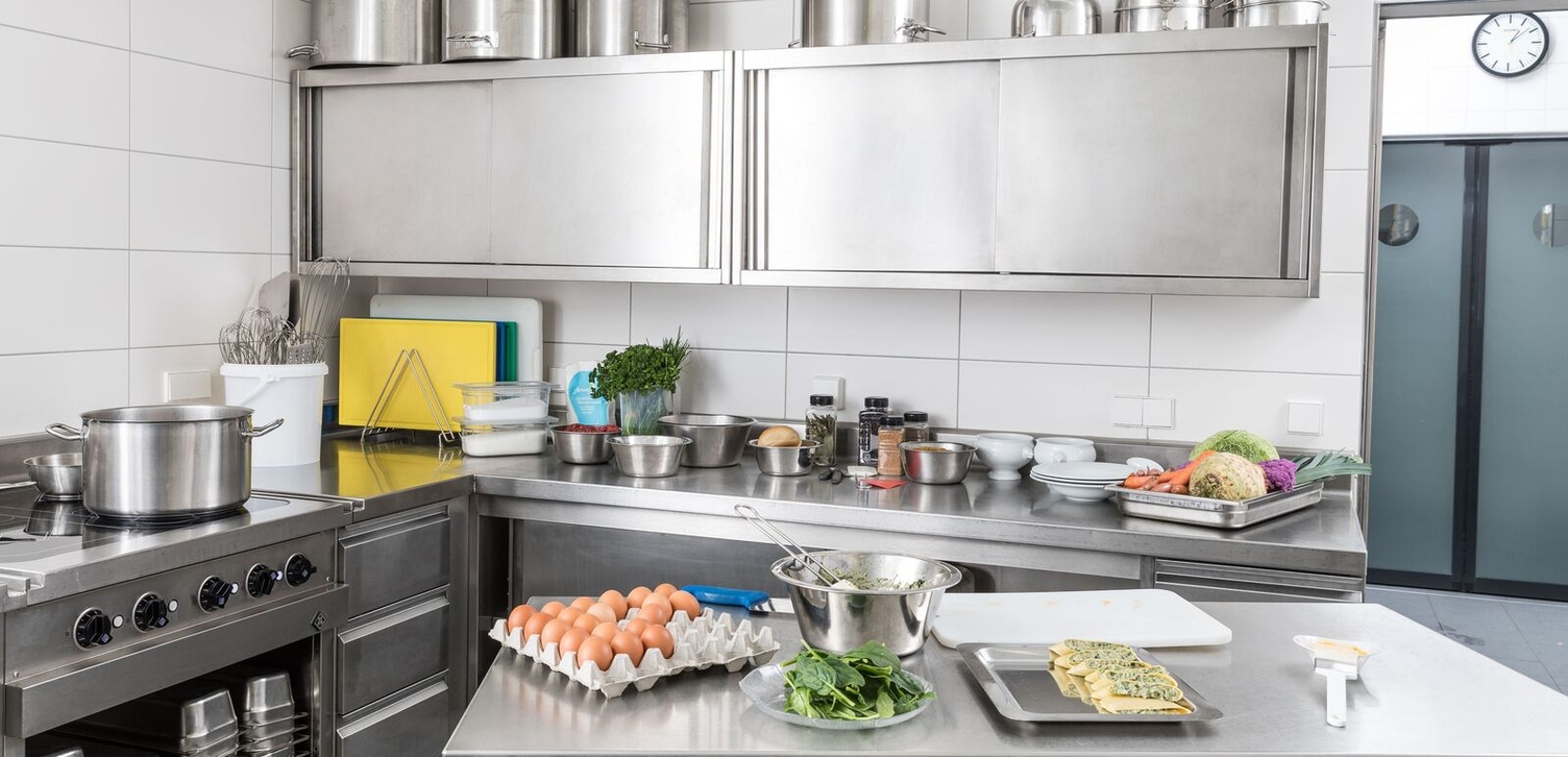 A commercial kitchen with various foods and cooking utensils