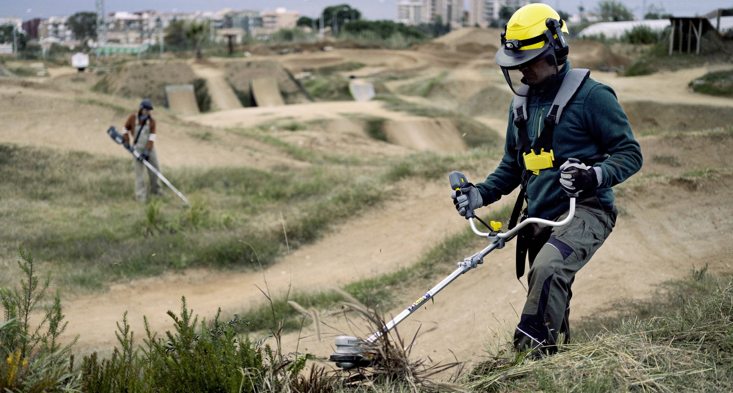 A man is trimming tall grass