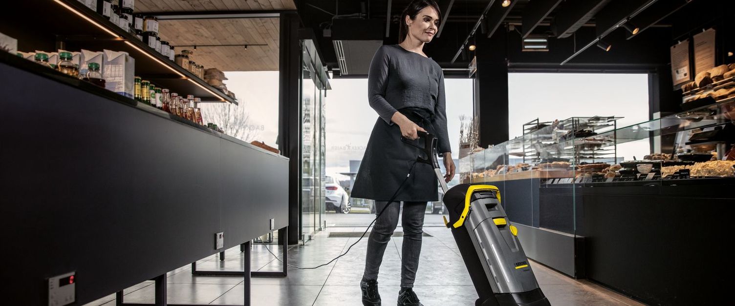 Bakery cleaning Woman with vacuum cleaner cleaning the floor inside a bakery.