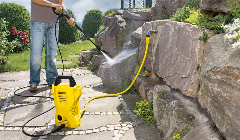 Hose connection Person cleaning stone wall with pressure washer