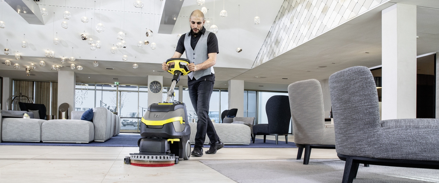 A person operating a Kärcher scrubber dryer