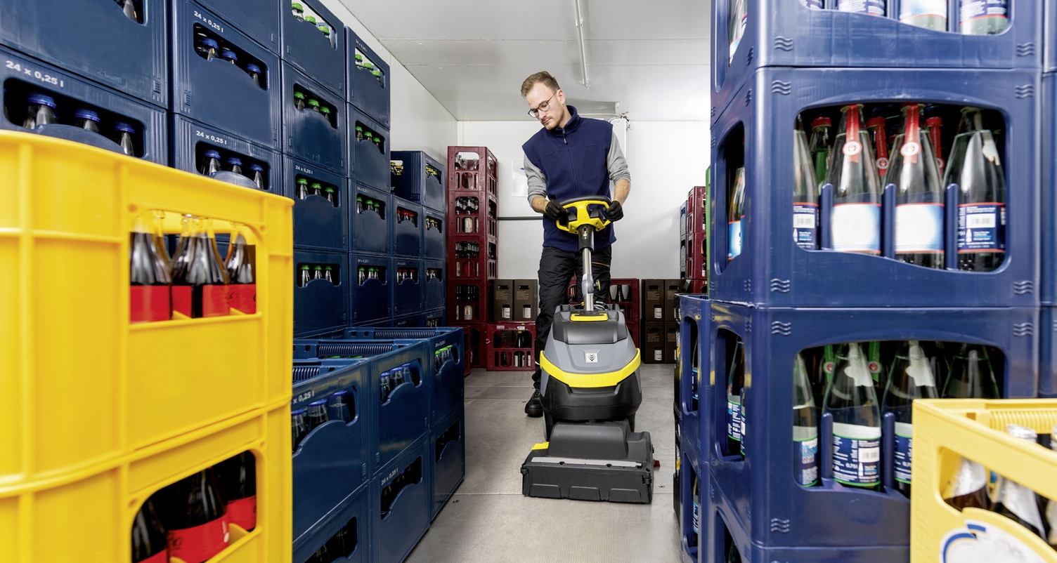 A person operates a scrubber-dryer in the cold room