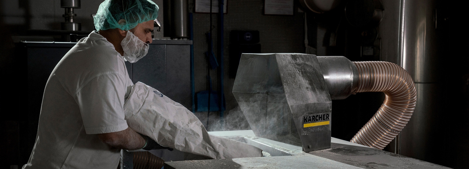 A man in front of an extraction system for flour dust in the food industry