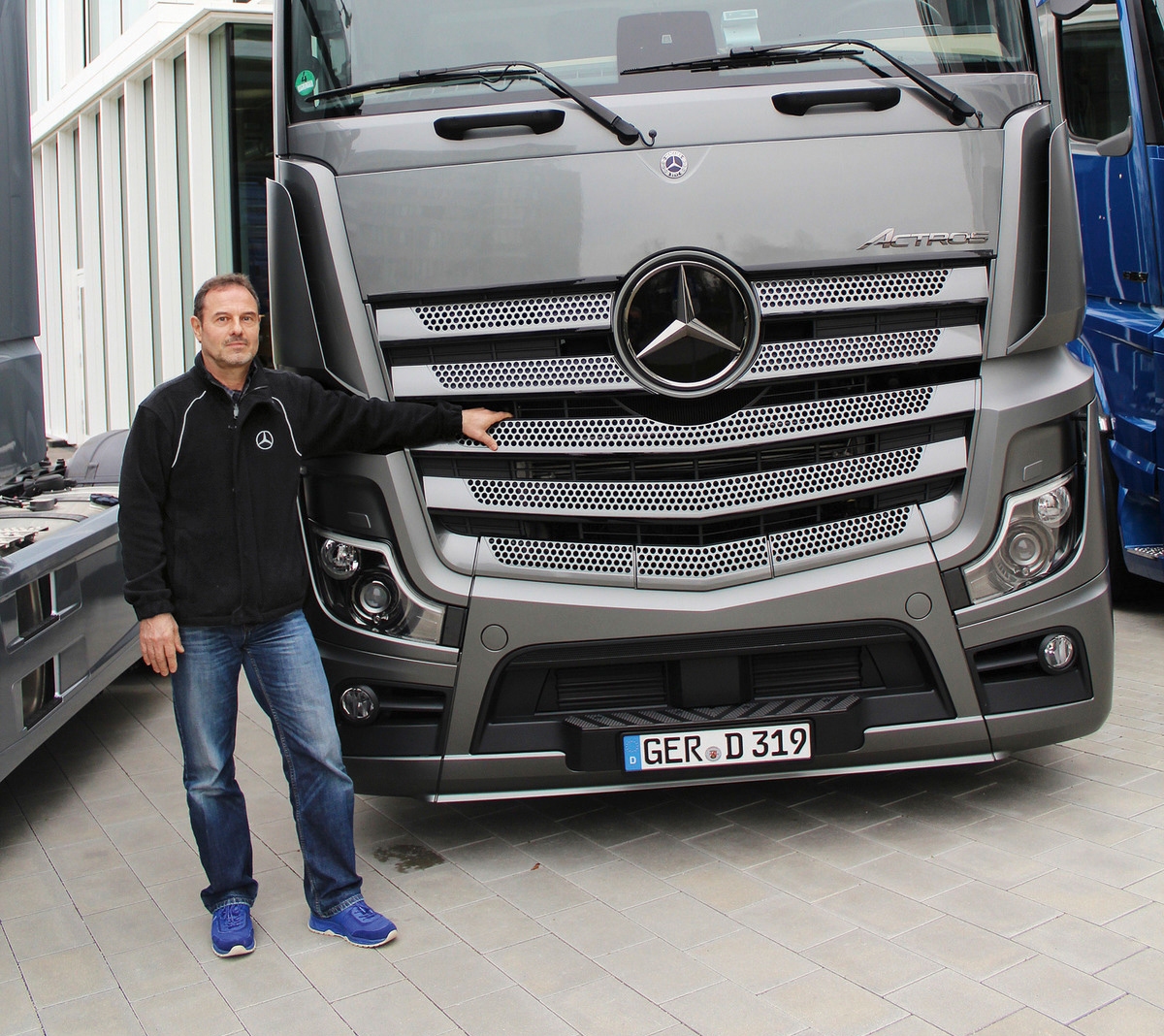 Dietmar Favorat standing next to a Daimler Truck Dietmar Favorat standing next to a Daimler Truck