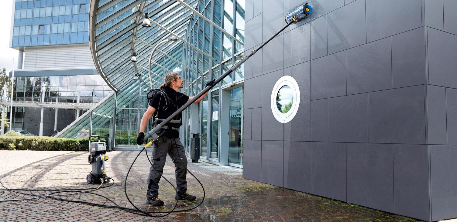 Metal facades are cleaned A person uses a Kärcher telescopic pole to clean a metal facade