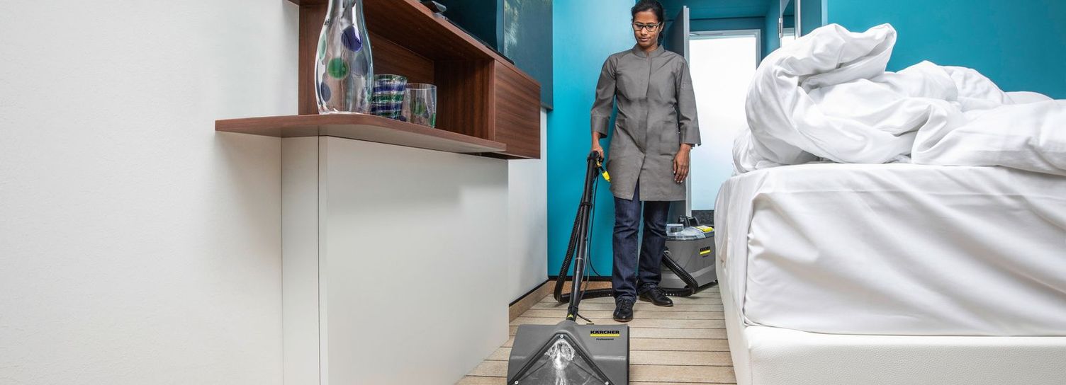 Basic carpet cleaning with a spray-extraction cleaner A woman cleans the floor of a room with a Kärcher spray-extraction cleaner