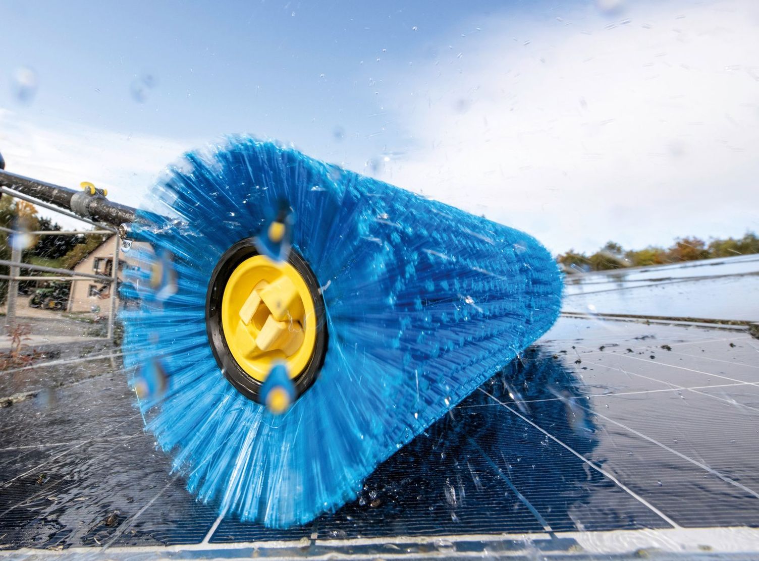 Cleaning photovoltaic panels with a roller brush