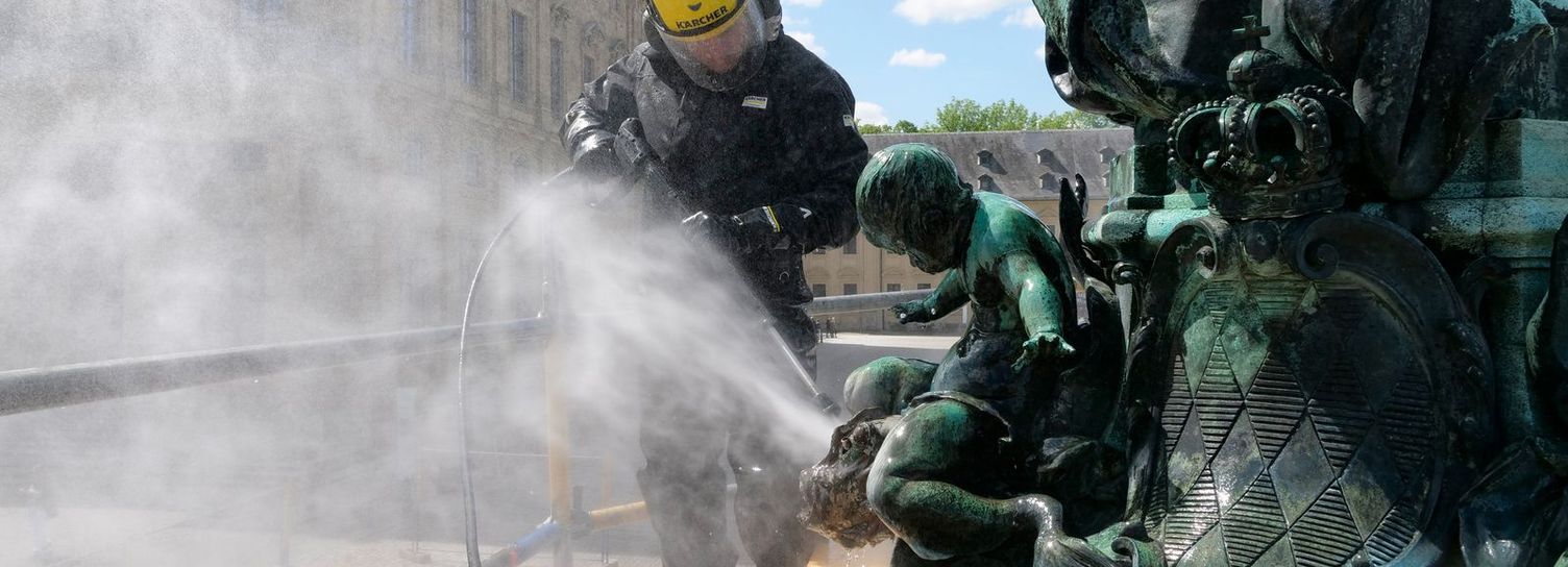 A person cleans metal with ultrahigh-pressure technology