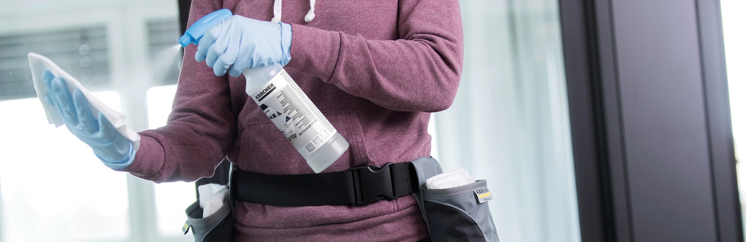 Person spraying a cloth with a disinfectant