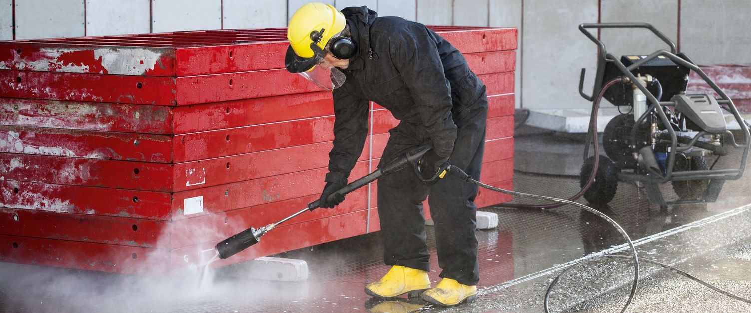 Cleaning formwork A person wearing protective clothing is cleaning formwork with a Kärcher Ultra-High-Pressure Cleaner