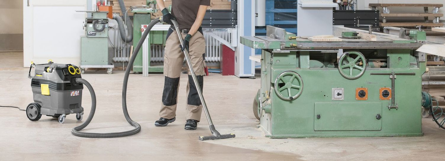A person vacuuming a workshop