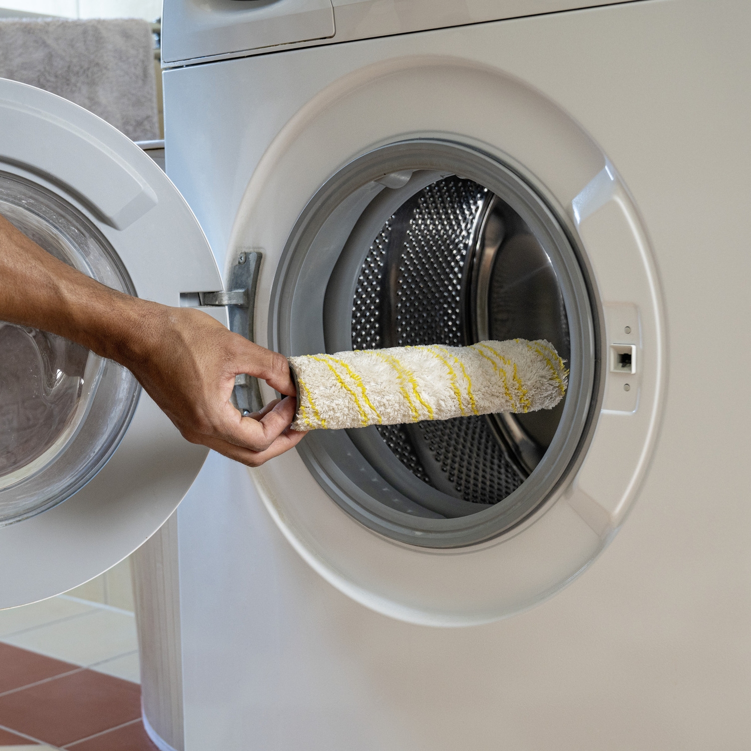 A microfibre roller from the Kärcher steam vacuum cleaner is placed in the washing machine for cleaning.