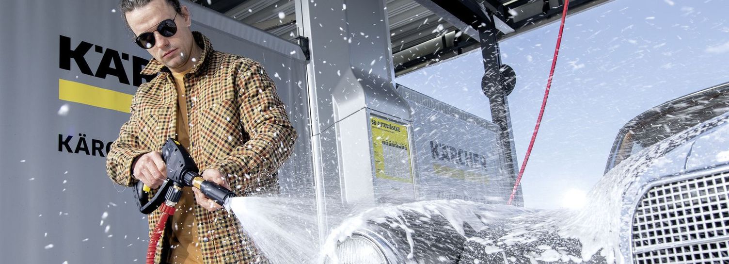 A man lathers up his classic car with a Kärcher power foam lance 