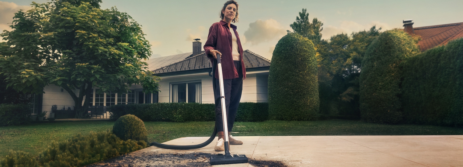 Person cleaning patio using Kärcher wet and dry vacuum cleaner