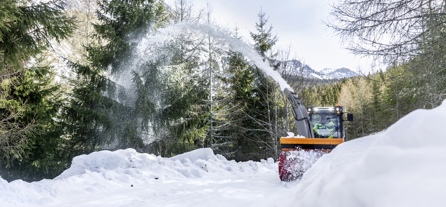 A snow blower is clearing a path of snow