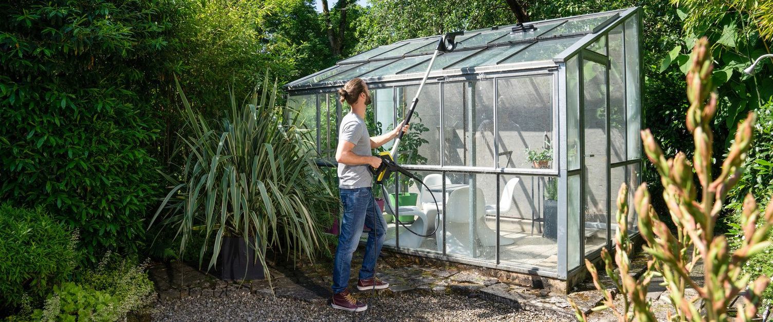 A man cleans his conservatory with the help of a Kärcher telescopic jet pipe